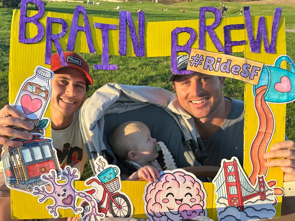 A family with a baby posing in the Brain Brew photo frame