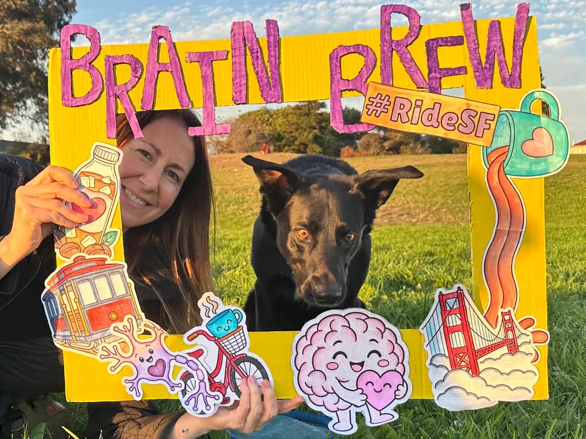 A person and a dog posing together in the Brain Brew photo frame