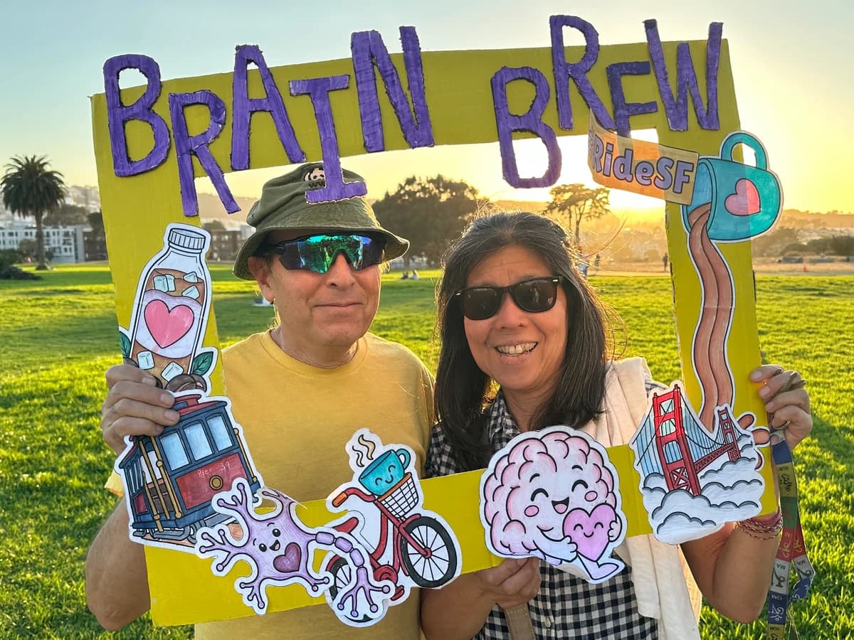 Two supporters with the Brain Brew photo frame in a sunny park