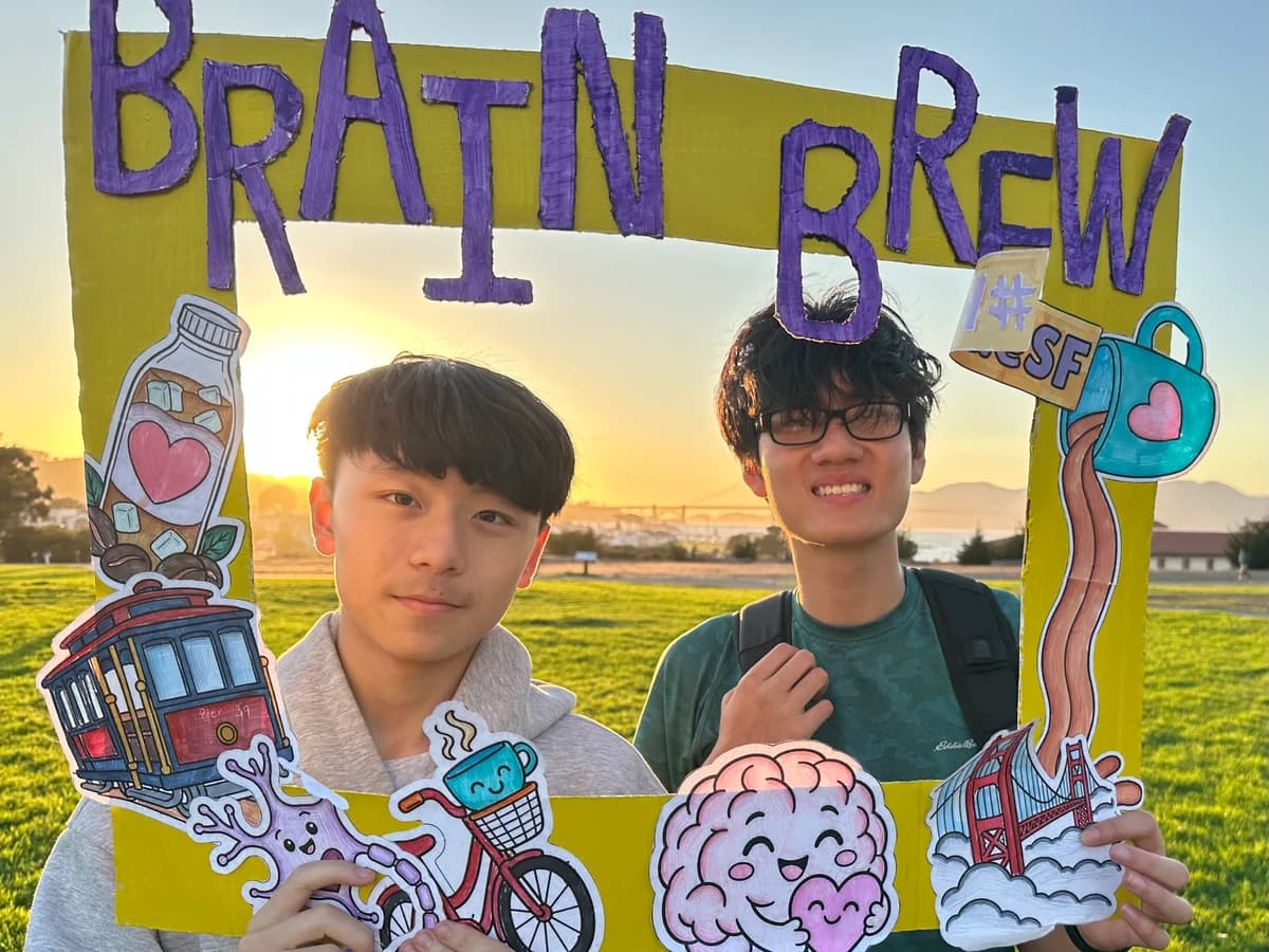 Two young people posing in the Brain Brew photo frame